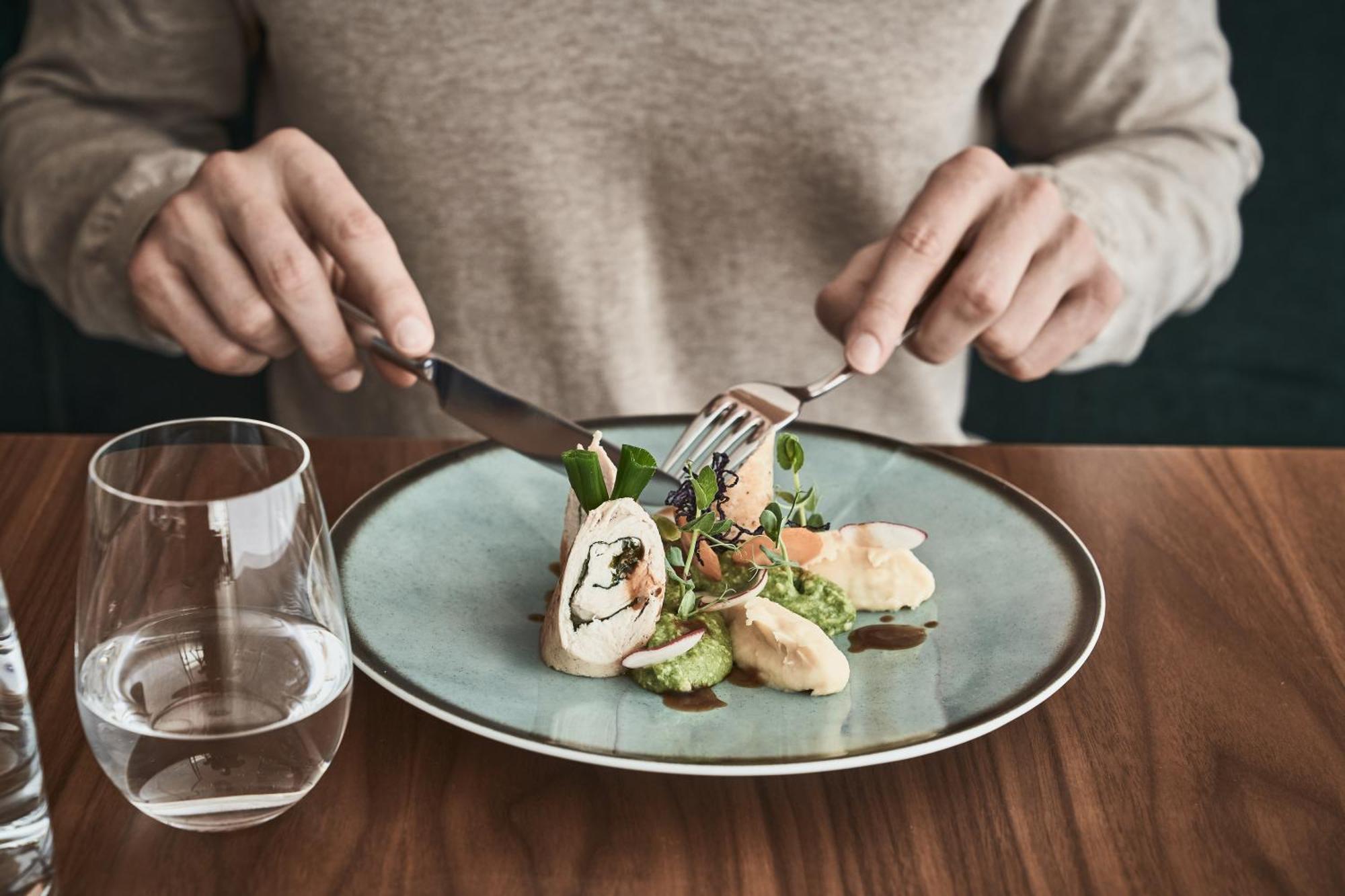 Falkensteiner Balance Resort Stegersbach - Adults Only Εξωτερικό φωτογραφία A person using a knife and fork to cut into a meal